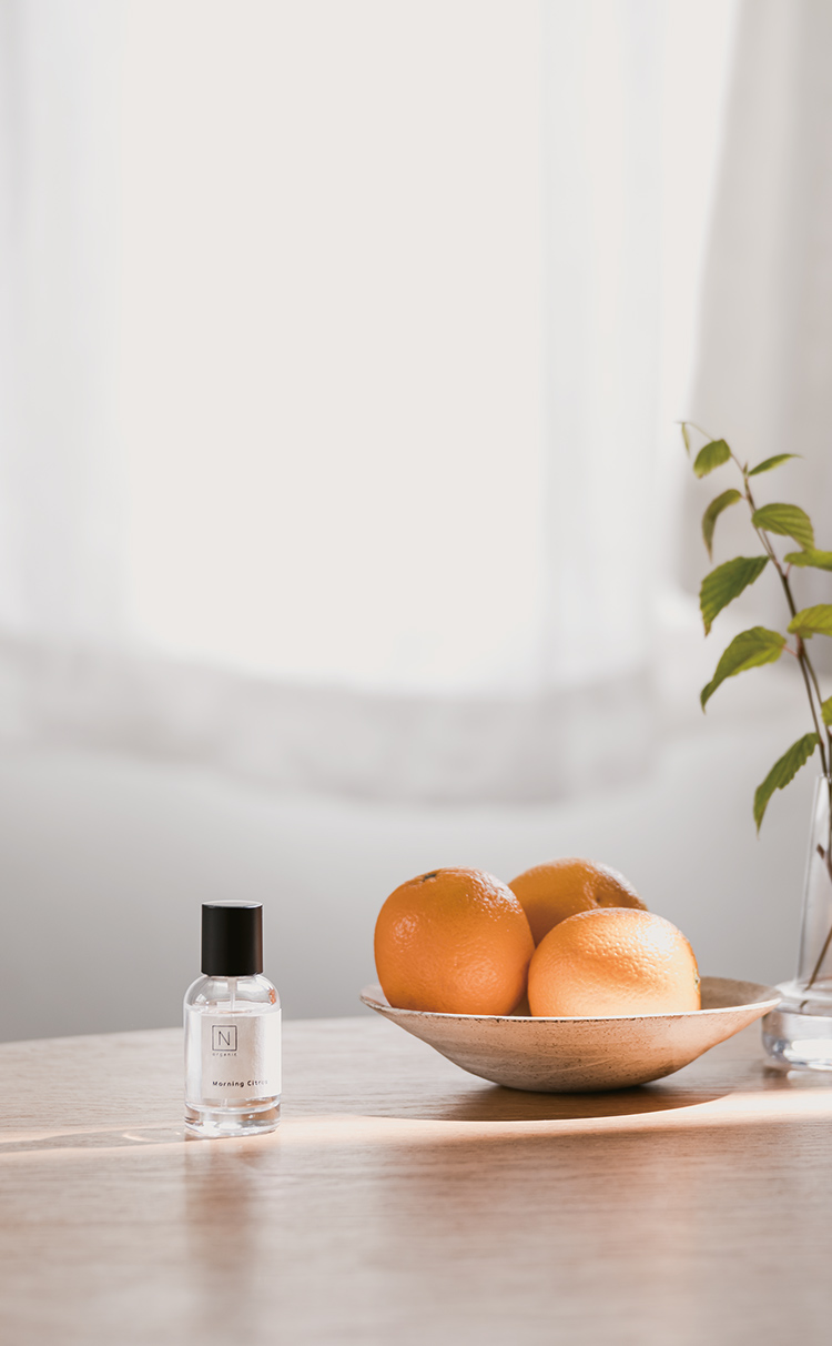 N organicのFragranceのMorning Citrusの商品の瓶が柑橘類の果物と一緒にテーブルの上に写ってる写真