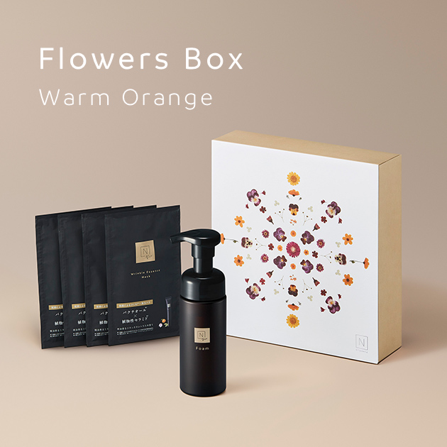 オレンジ色の背景に「Flowers Box Warm Orange」のテキストにN organic Vieのクリアホイップフォーム・リンクルパックエッセンスマスクの商品と花形デザインのギフトの箱の写真