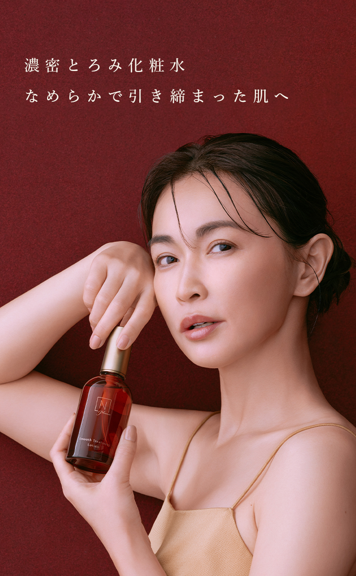 赤い背景に長谷川京子がN organic Plenumの「スムーストリートメント　ローション」の商品を肩に持っている写真に「濃密とろみ化粧水　なめらかで引き締まった肌へ」のテキスト 